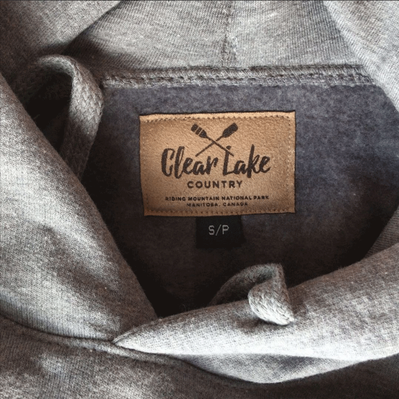 Clear lake country Riding Mountain National Park Manitoba, Canada microsuede neck tag on grey hoodie.