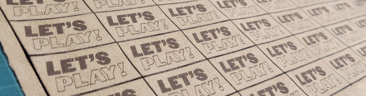Grid of let's Play tan and brown microsuede tags in rows on green grid background.