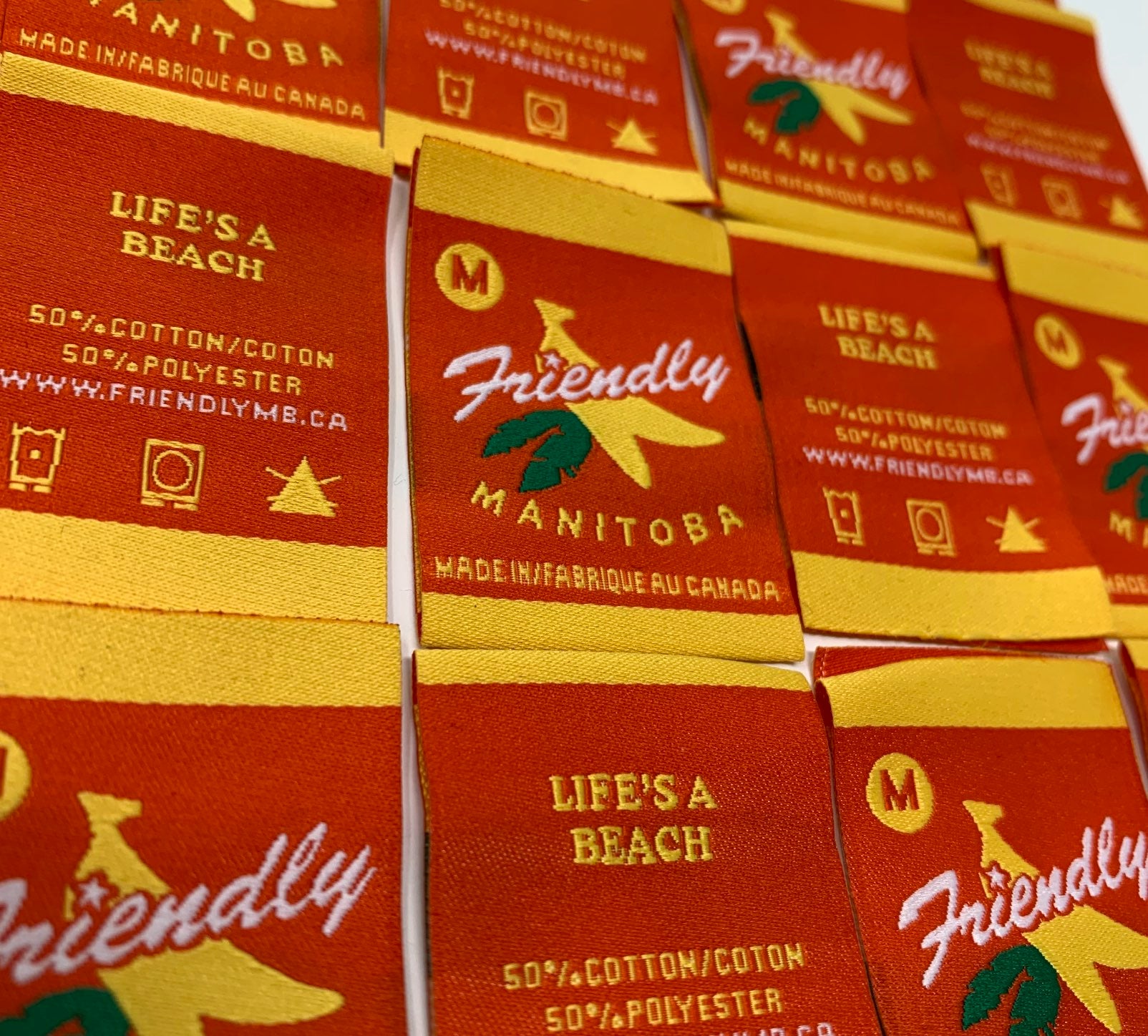 Grid of red, yellow and green Friendly Manitoba neck tags.